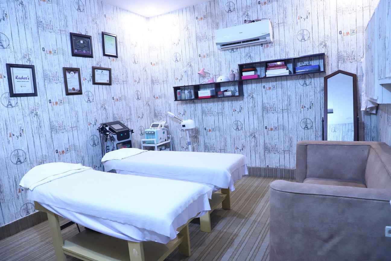 hair salon interior with luxury styling chairs, gold-framed mirrors, and chandeliers.